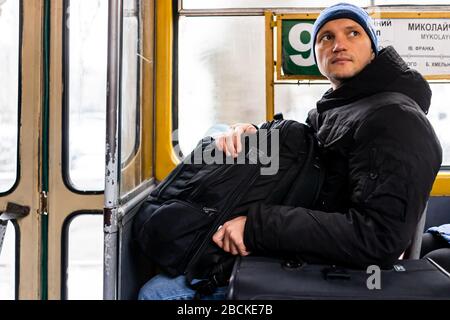 Lviv, Ukraine - 28 décembre 2019: L'intérieur du tramway à Lvov en hiver avec l'homme touriste assis sur place à l'intérieur par le nombre de téléphérique et la sortie de porte Banque D'Images