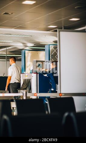 Articles de transport de voyageurs passant par le scanner à rayons X. Banque D'Images