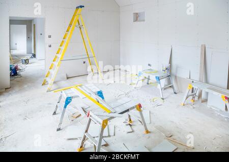 Installation de plaques de plâtre à l'intérieur d'une pièce lors d'une rénovation de la maison Banque D'Images