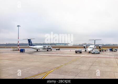 Varsovie, Pologne - 23 janvier 2020 : piste d'aéroport international de Chopin avec des voitures de service alimentant l'avion par la porte du terminal à Varsovie Banque D'Images