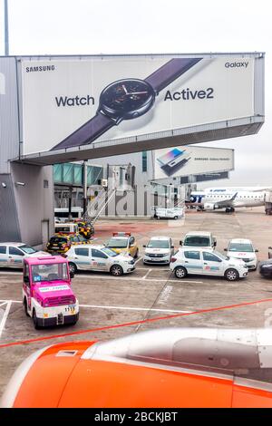 Varsovie, Pologne - 23 janvier 2020: L'aéroport international de Chopin pendant la journée avec des voitures de service par terminal gate et la publicité pour Samsung Watch Banque D'Images