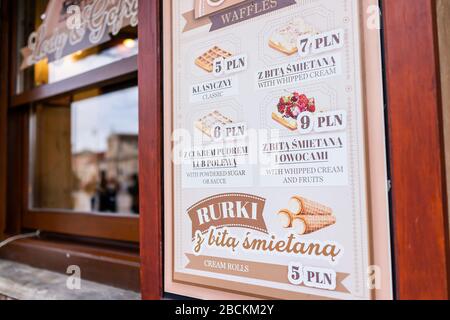 Varsovie, Pologne - 25 décembre 2019: Vieille ville historique rue dans la capitale Krakowskie Przedmiescie hiver jour et signe pour le dessert café menu par le vent Banque D'Images