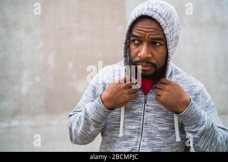 Portrait d'un homme sportif portant des vêtements de sport sur fond gris. Sport et mode de vie sain. Banque D'Images