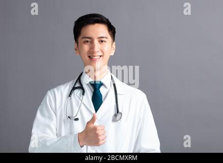 Portrait du jeune médecin asiatique masculin avec les pouces vers le haut Banque D'Images