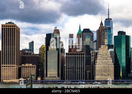 Vue sombre et contrastée sur les bâtiments du bord de mer de New York de l'autre côté de la rivière East, par temps nuageux Banque D'Images