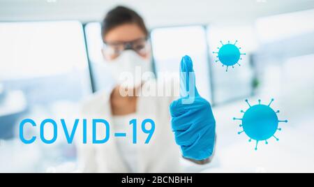 COVID-19 texte signe un chercheur de laboratoire heureux pouces vers le haut dans le succès de trouver un vaccin de guérison pour la pandémie de coronavirus. Équipement de protection individuelle médecin portant des gants, un masque et des lunettes de protection. Banque D'Images