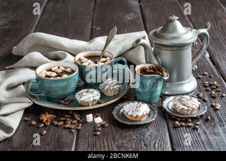 Rustique, toujours la vie avec des tasses bleues vintage de café noir, gâteaux, guimauves et café powter antique entouré de serviettes en lin gris et de café Banque D'Images