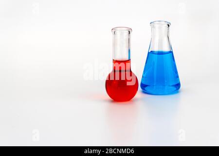 Verrerie de laboratoire avec liquide sur fond blanc. Flacon chimique en verre avec réactif. Banque D'Images