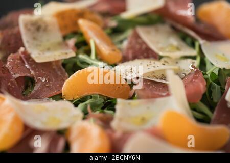 Salade avec prosciutto, tangerines et fromage d'époque Banque D'Images