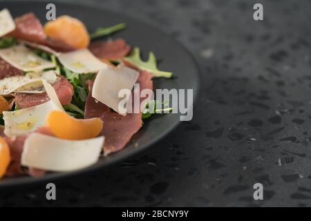 Salade avec prosciutto, mandarines et fromage d'époque avec espace de copie Banque D'Images