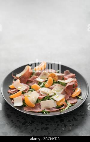 Salade avec prosciutto, mandarines et fromage d'époque avec espace de copie Banque D'Images