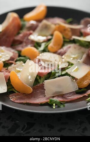 Salade avec prosciutto, tangerines et fromage d'époque Banque D'Images