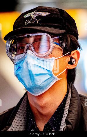 Un passager portant un masque facial comme mesure préventive vue au hall de départ.Portes fermées et salles de départ à l'aéroport de Schiphol en période de menaces de coronavirus. L'aéroport rétrécit ce que l'aéroport lui-même appelle Kern-Schiphol. Cela signifie que les installations permettant de quitter les passagers se poursuivront sous une forme affinée. Banque D'Images