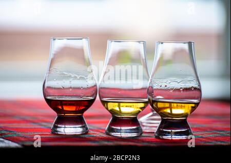 Lunettes spéciales en forme de tulipe avec couvercle pour la dégustation de whisky écossais sur la distillerie en Ecosse, au Royaume-Uni et au tartan rouge Banque D'Images