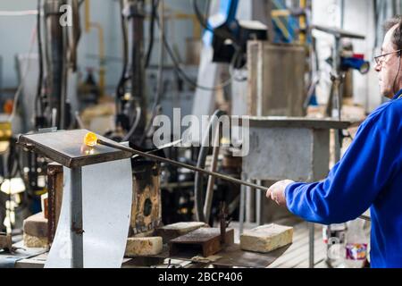 Beloslav / Bulgarie - 5 mai 2019: Souffleur de verre formant beau morceau de verre. Un artisan en verre brûle et souffle une pièce d'art. Banque D'Images