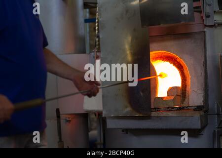 Beloslav / Bulgarie - 5 mai 2019: Souffleur de verre formant beau morceau de verre. Un artisan en verre brûle et souffle une pièce d'art. Banque D'Images