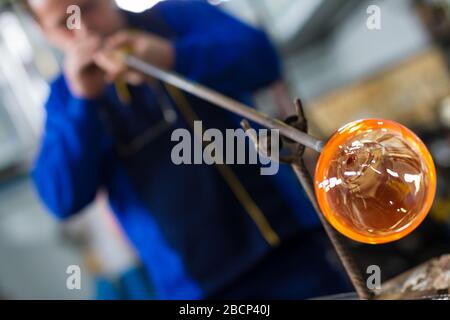 Beloslav / Bulgarie - 5 mai 2019: Souffleur de verre formant beau morceau de verre. Un artisan en verre brûle et souffle une pièce d'art. Banque D'Images