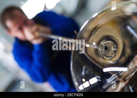 Beloslav / Bulgarie - 5 mai 2019: Souffleur de verre formant beau morceau de verre. Un artisan en verre brûle et souffle une pièce d'art. Banque D'Images