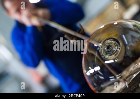 Beloslav / Bulgarie - 5 mai 2019: Souffleur de verre formant beau morceau de verre. Un artisan en verre brûle et souffle une pièce d'art. Banque D'Images