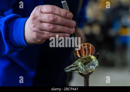 Beloslav / Bulgarie - 5 mai 2019: Souffleur de verre formant beau morceau de verre. Un artisan en verre brûle et souffle une pièce d'art. Banque D'Images