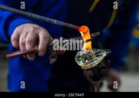 Beloslav / Bulgarie - 5 mai 2019: Souffleur de verre formant beau morceau de verre. Un artisan en verre brûle et souffle une pièce d'art. Banque D'Images