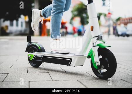 Une jolie jeune femme voyage en ville avec un scooter électrique Banque D'Images