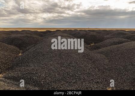 De grandes piles d'asphalte anciennes dans la steppe après la réparation des routes, Kazakhstan Banque D'Images