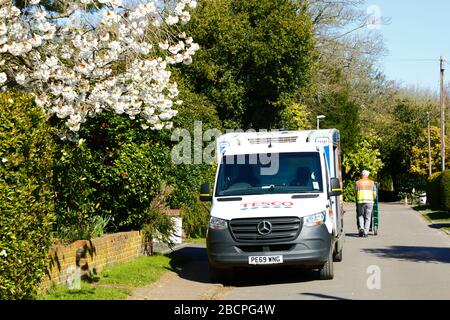 5 avril 2020, Southborough, Kent, Royaume-Uni : un livrant Tesco livre une commande de nourriture le dimanche de Palm, une magnifique journée de printemps. Ces derniers jours, les cerisiers ornementaux ont commencé à s'épanouir. En raison des mesures imposées par le gouvernement en matière de quarantaine/de verrouillage pour réduire la propagation du coronavirus pendant la pandémie mondiale, de nombreuses personnes ont leur nourriture et leurs fournitures livrées pour réduire leur contact avec d'autres personnes. Banque D'Images