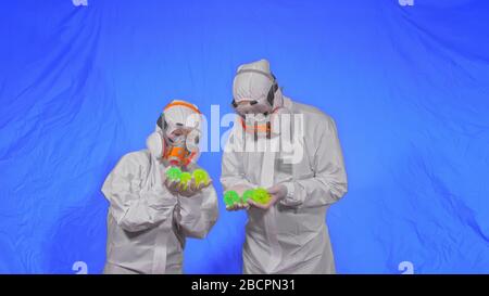 Le médecin du respirateur présente un modèle de virus. Ralenti. Une femme portant un masque de peinture aérosol de protection médicale. Pointe de balle verte, épi. Banque D'Images