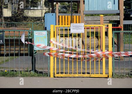 Swansea, Pays de Galles, Royaume-Uni - 5 avril 2020: Aire de jeux extérieure fermée. La zone de jeu pour enfants a verrouillé la porte avec du ruban rouge et blanc pour empêcher les gens de se rassembler. Coron Banque D'Images