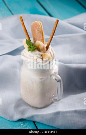 milkshakes aux biscuits, crème glacée et crème fouettée. sur un fond de table bleu Banque D'Images