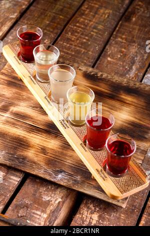 Ensemble coloré de cocktails alcoolisés dans des tireurs de verres sur une table en bois pour une fête alcoolique. Ensemble de vin, brandy, liqueur, teinture, cognac, W Banque D'Images