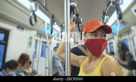 Une femme voyage une balade caucasienne à l'airtrain en train terrestre avec un masque médical de protection. Fille touristique à airtrain avec respirateur. Masque de personnes. Banque D'Images