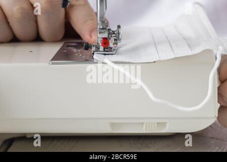 fabriquer des masques médicaux de protection à partir de coronavirus fait à la main couture. créer zéro déchet réutilisable du masque vous-même. Banque D'Images