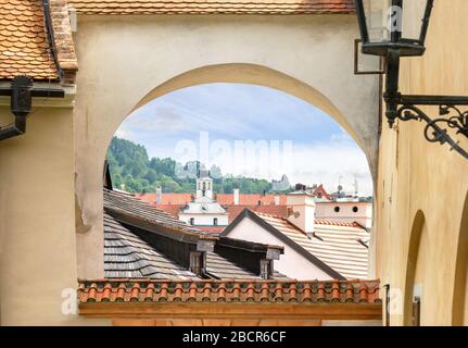 Vue sur les toits des maisons de Cesky Krumlov à travers l'arche. République tchèque. Banque D'Images