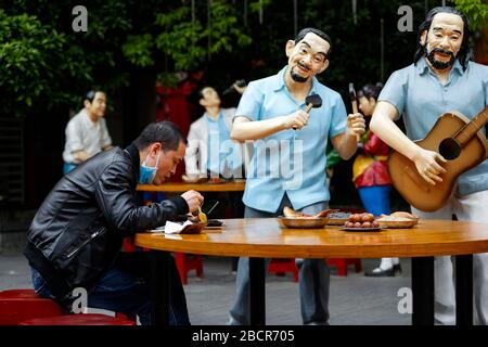 Wuhan, la province chinoise de Hubei. 5 avril 2020. Un homme a un repas à côté de statues dans un restaurant extérieur à Wuhan, dans la province de Hubei en Chine centrale, le 5 avril 2020. Crédit: Shen Bohan/Xinhua/Alay Live News Banque D'Images