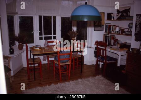 Jeune fille portant des salopettes rayées Big Smith assis à une table faisant un puzzle, Royaume-Uni 1973 Banque D'Images