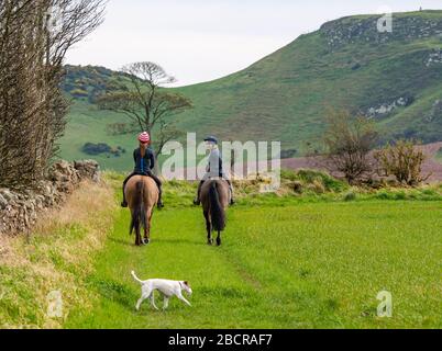 East Lothian, Écosse, Royaume-Uni. 5 avril 2020. Météo au Royaume-Uni : l'est du pays ressent enfin la chaleur du soleil de printemps car ceux qui vivent dans la zone rurale prennent leur exercice quotidien. Une femme et une fille qui monte sur les chevaux autour des bords des champs de récolte Banque D'Images