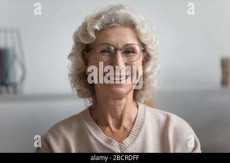 La tête a tiré près de heureuse vieille femme âgée dans des lunettes. Banque D'Images