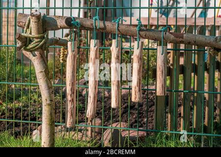 sur une clôture se trouve un carillon autosculpté en bois Banque D'Images