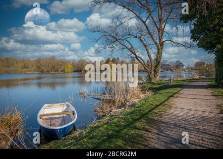 un bateau à ramer est amarré sur la rive d'un petit lac par beau temps Banque D'Images