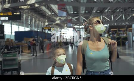 Femme et enfant bébé touriste caucasien à l'aéroport avec porter un masque médical de protection. Famille en quarantaine isolée. Covid-19 de coronavirus. Banque D'Images