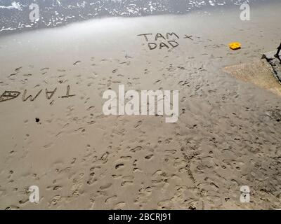 Écrire le mot papa écrit sur une plage de sable Banque D'Images