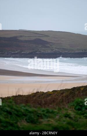 Un surfeur dans la mer à Crantock Beach près de Newquay, Cornwall. Banque D'Images