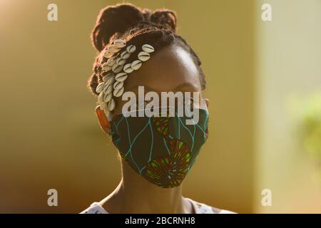 Une femme kenyane portant un masque fait maison à partir d'un tissu Kanga traditionnel pour la protection contre la pandémie de covid-19. Les masques chirurgicaux sont en sup court Banque D'Images