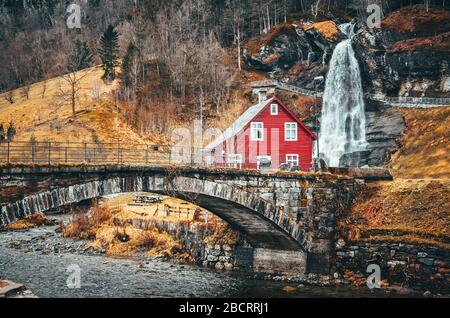 Chute d'eau et maison rouge typique dans le parc national de Norvège Tvindefossen Banque D'Images