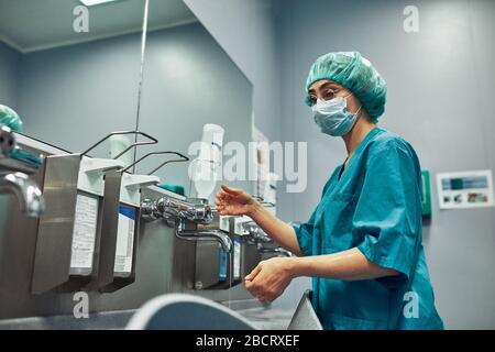 Le médecin se lave les mains avant la chirurgie. Concept de stérilité. Un chirurgien professionnel se lave les mains dans une pièce spéciale avant l'opération. Banque D'Images