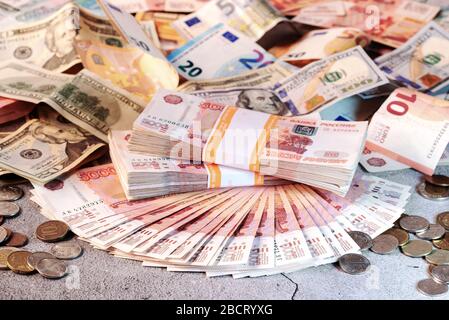 Grande pile et ventilateur de billets, roubles russes et pièces de monnaie différentes sur une surface grise Banque D'Images