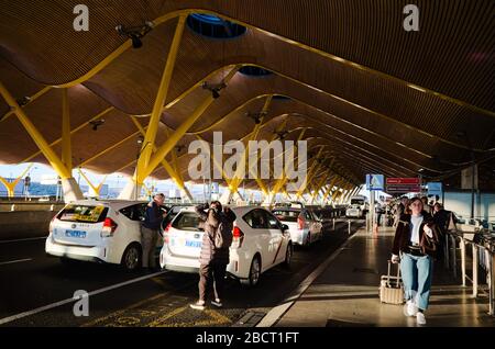 Madrid, Span - Janvier 2020: Les personnes arrivant en taxi sur le parking et allant avec des bagages à l'aéroport international de Madrid Barajas. Banque D'Images