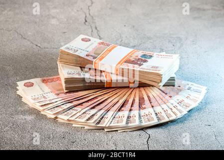 Grande pile et ventilateur de billets, roubles russes sur une surface en béton gris Banque D'Images